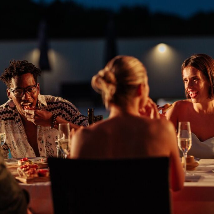 Group,Of,Friends,Dining,And,Laughing,Together,At,An,Outdoor