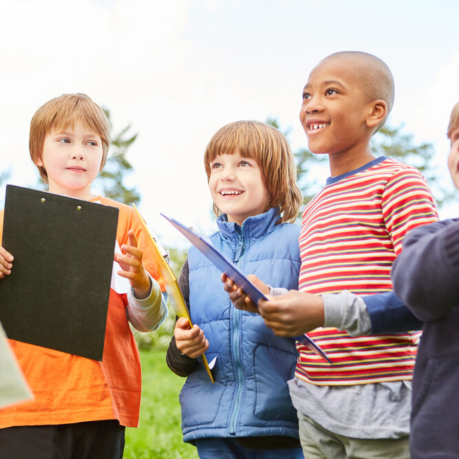 Group,Of,Kids,With,Clipboards,On,Scavenger,Hunt,In,Nature