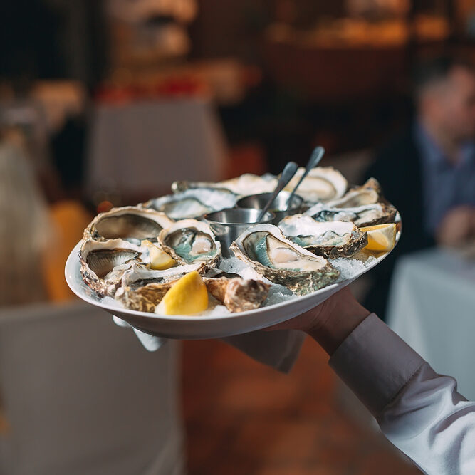 A,Waiter,Holds,A,Serving,Of,Oysters,In,A,Restaurant