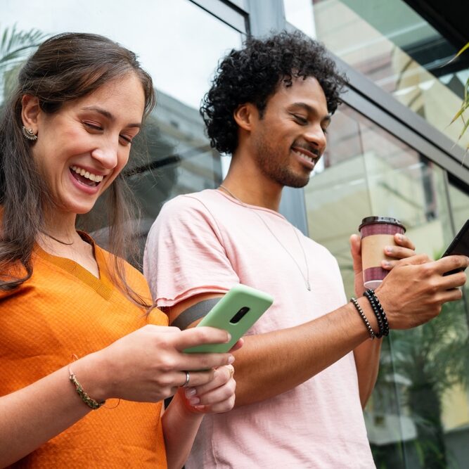 Happy,Friends,Using,Mobile,Phone,For,Fun,In,Coffee,Shop